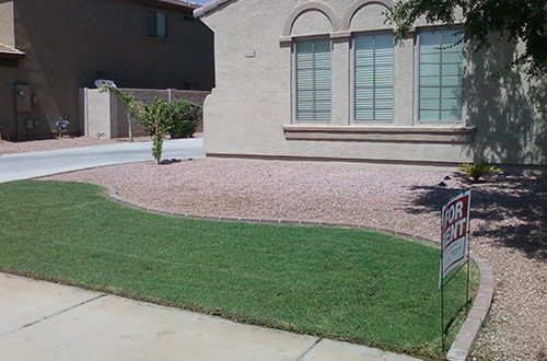 A person standing in front of a house with a dog.