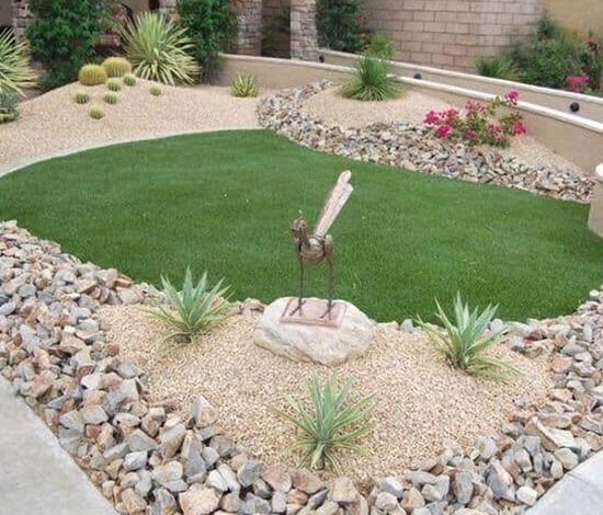 A bird statue in the middle of a garden.